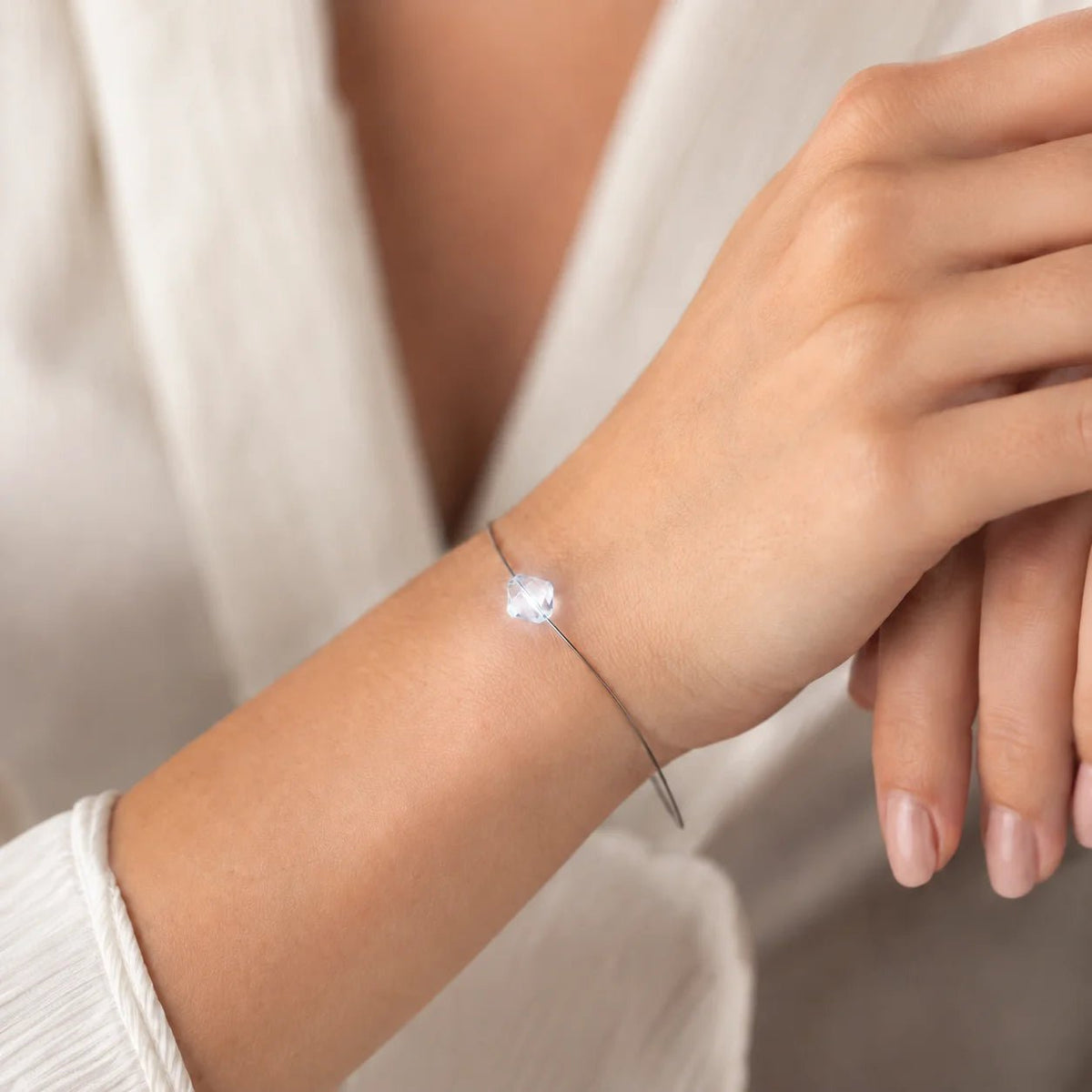 Frau mit leuchtendem weißen Swarovski® Bicone-LED-Armband.