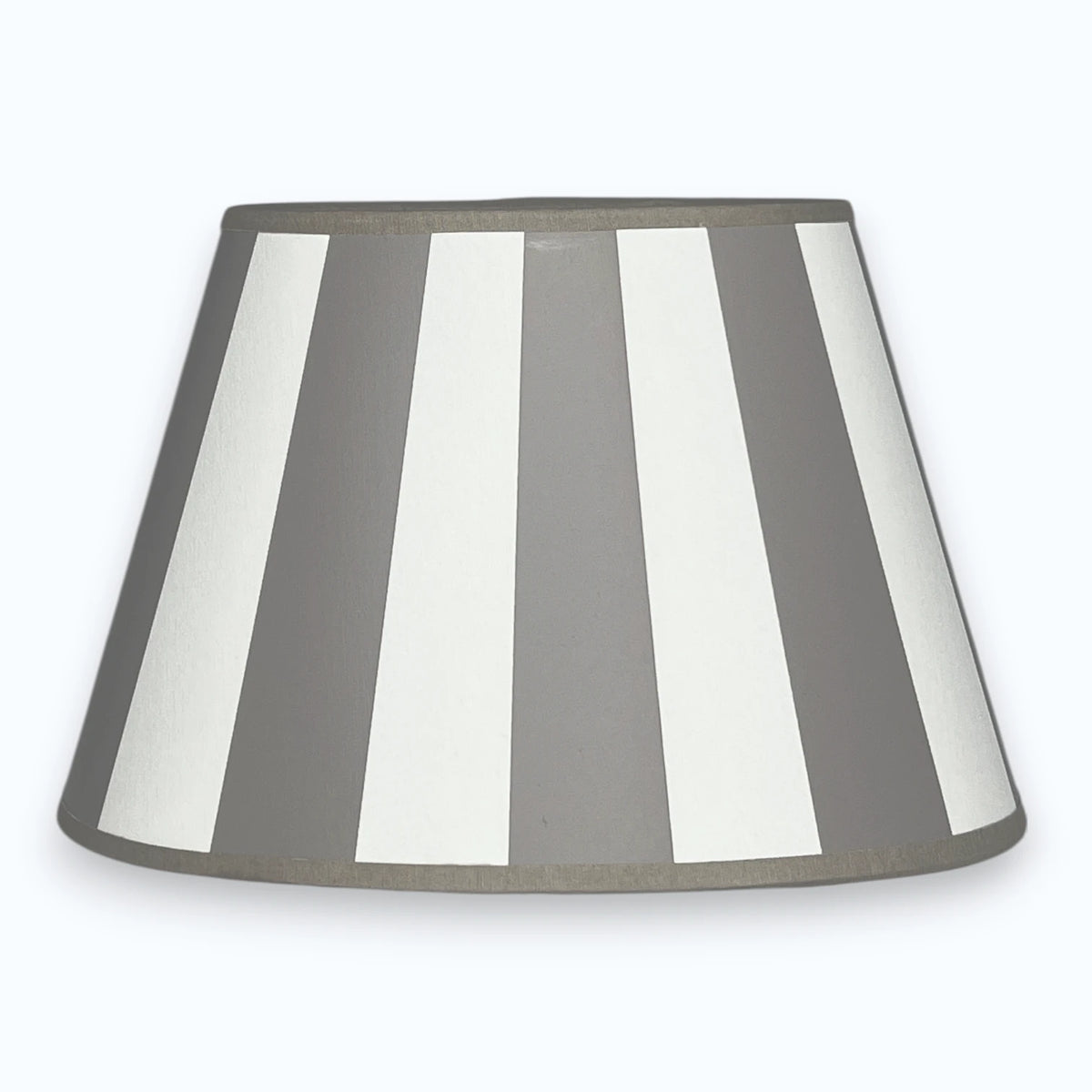 Ovaler Lampenschirm aus Stoff in Taupe und Weiß mit Streifendesign  auf hellem Hintergrund.