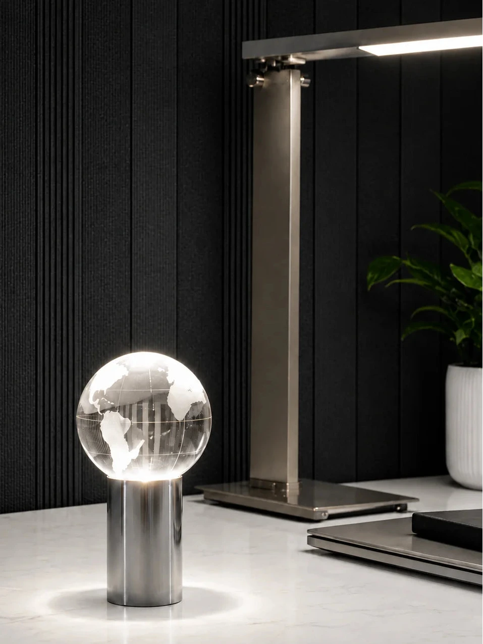 Moderne Design Tischlampe mit leuchtender Globus Kugel auf Marmor Tisch neben eleganter LED Schreibtischlampe