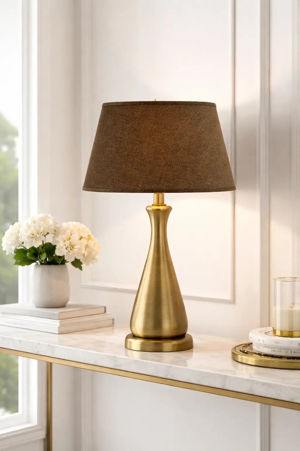 Brauner ovaler Leinen-Lampenschirm auf goldfarbenem Lampenfuß im hellen Wohnraum, dekoratives Wohnbeispiel mit warmer Lichtwirkung, Light & Living, Artikelnummer 32435-1781