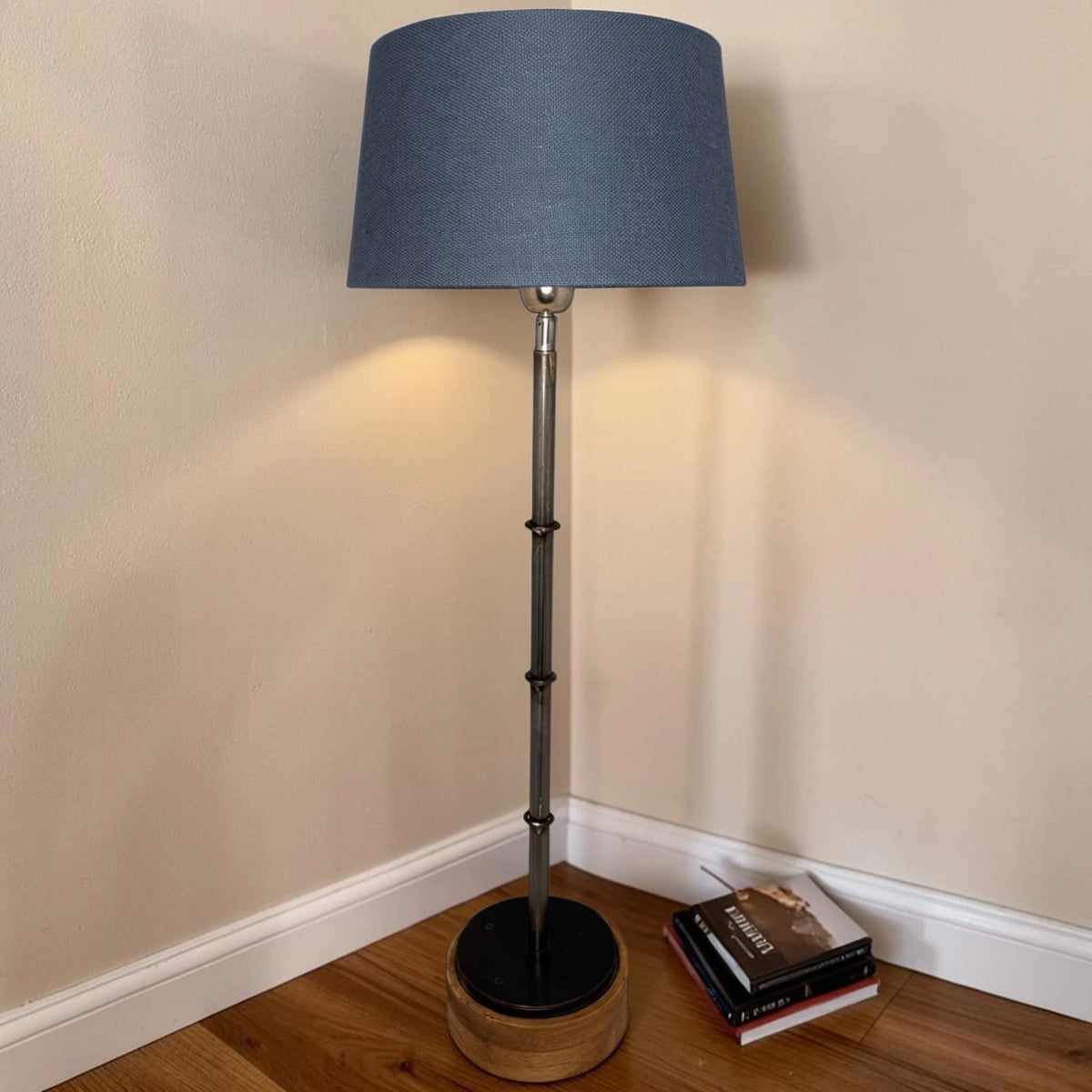 Blauer konischer Lampenschirm auf einer Stehlampe im Wohnraum
