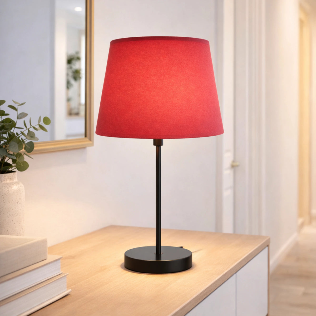 Roter Lampenschirm auf moderner Tischlampe mit schwarzem Fuß