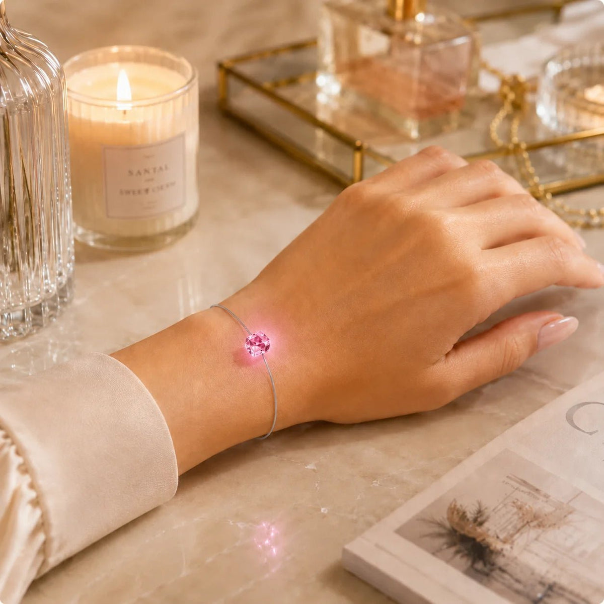 Leuchtendes LED Kristall Armband in Pink mit feinem grauem Edelstahlband am Handgelenk einer Frau.