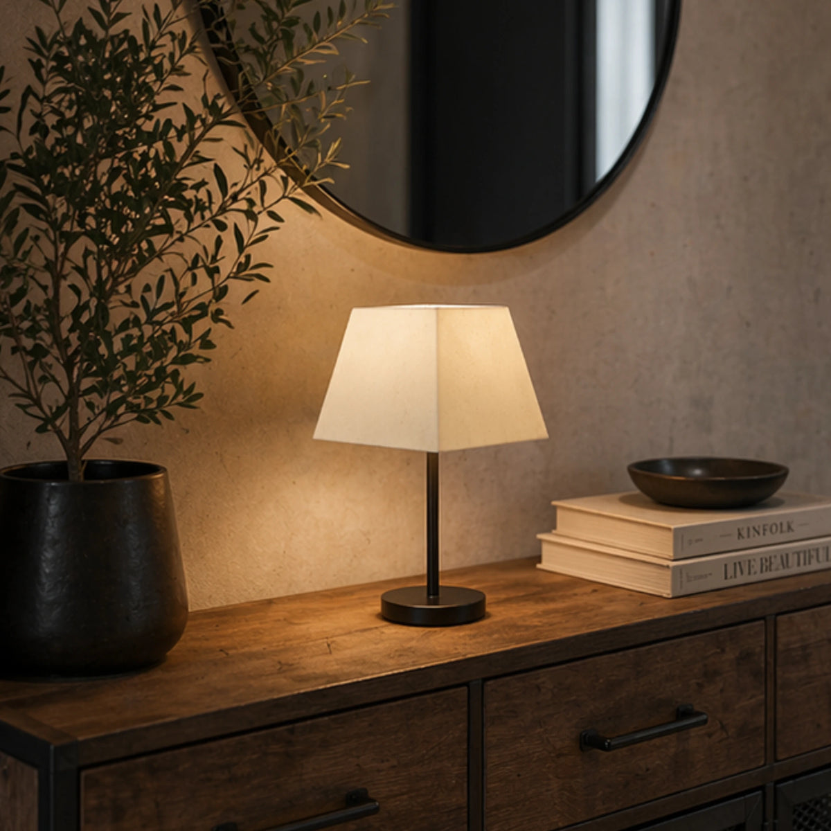Quadratischer Lampenschirm in Creme auf schwarzer Tischlampe in modernem Wohnraum mit warmer Beleuchtung – Light & Living