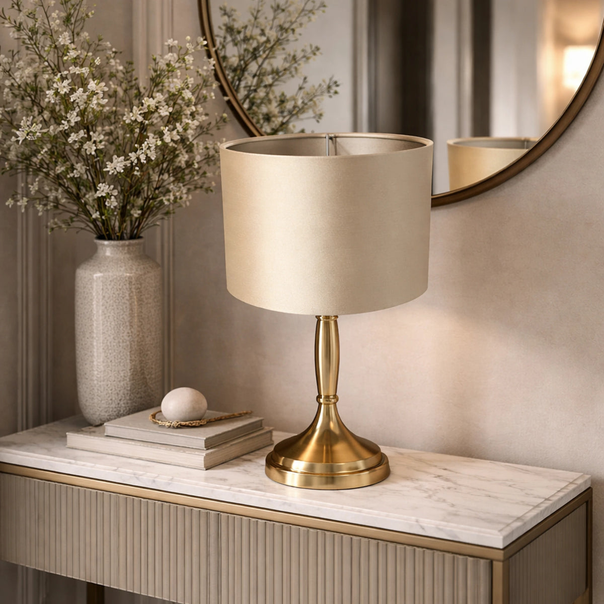Light & Living Lampenschirm MONACO Gold, Artikelnummer 2220013, goldener zylinderförmiger Stofflampenschirm auf goldfarbenem Lampenfuß in einem wohnlichen Innenraum
