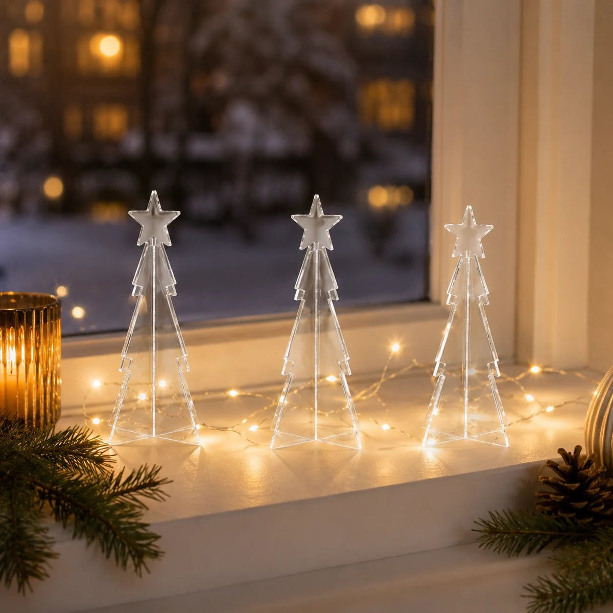 Drei klare Mini-Acryl-Tannenbäume als Weihnachtsdekoration.