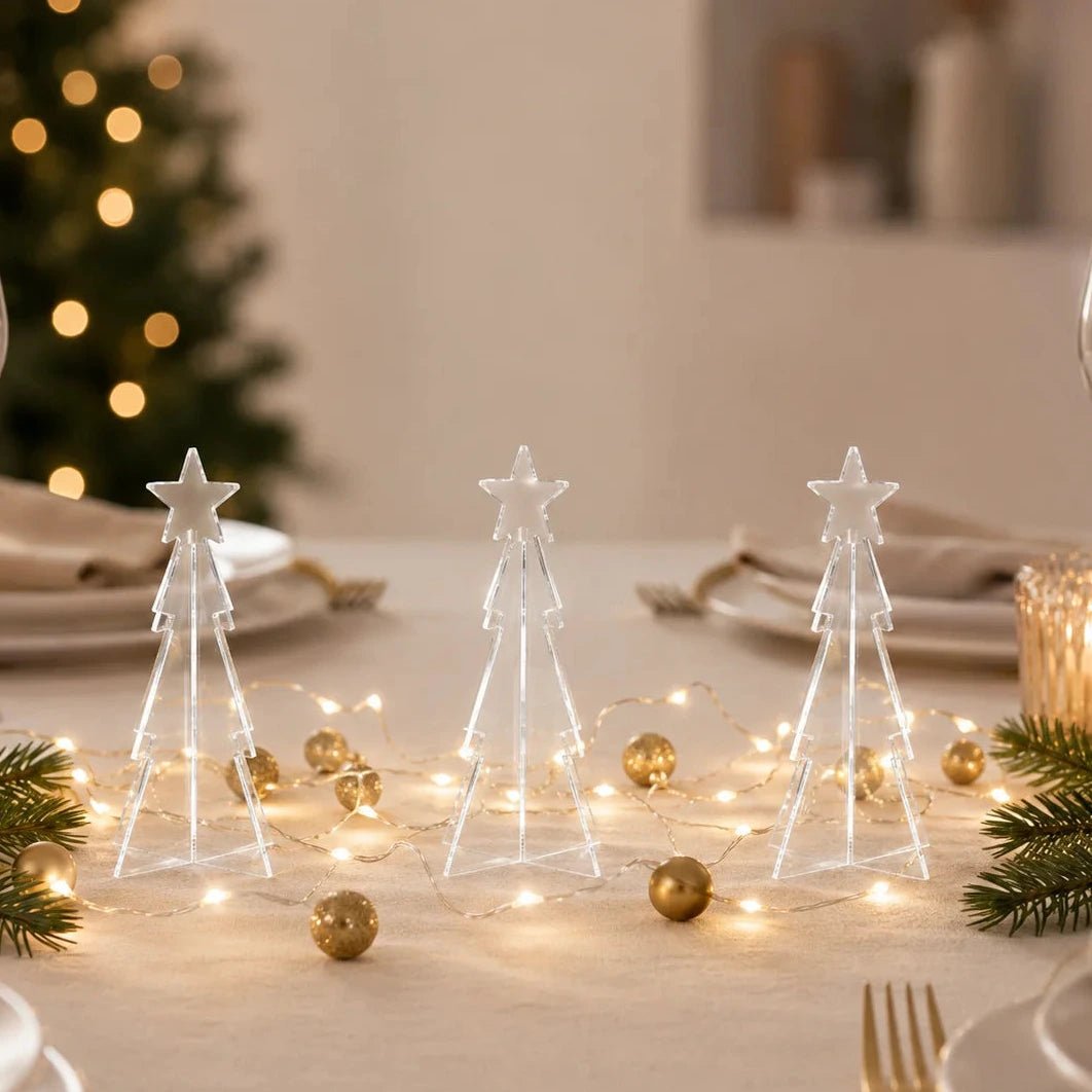 Drei klare Mini-Acryl-Tannenbäume als weihnachtliche Tischdekoration mit warmweißen Lichterketten