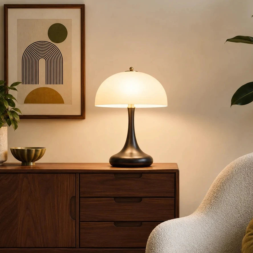 Retro Tischlampe in Schwarz und Gold neben Sessel, warme Wohnzimmer Beleuchtung im klassischen Mid Century Stil