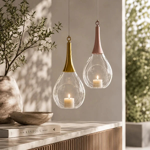 Stilvolle hängende Glas-Windlichter mit Kerzenlicht in einem modernen, warmen Wohninterieur.